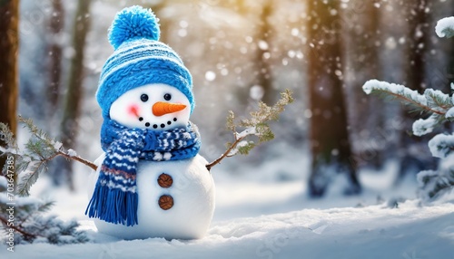 Cute snowman in a blue knitted bobble hat and scarf in a winter forest with copy space.