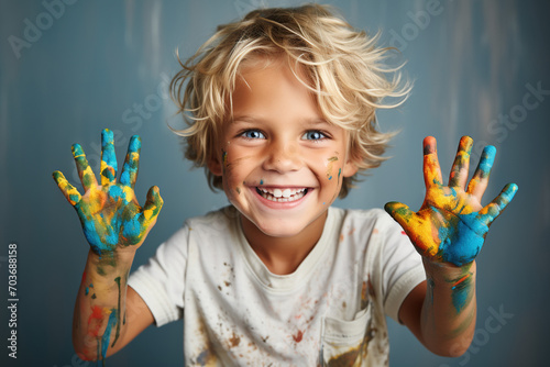 Portrait of young child with stained palms of hands spotted colorful studio background looking into the camera with playful look. Creativity developing extra courses for kids advertisement concept