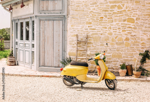 Nostalgic yellow scooter and plants by vintage building