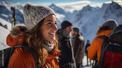 Young woman in winter clothes smiling in front of snow-capped mountains