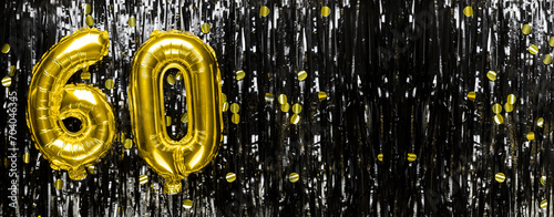 Gold foil balloon number number 60 on a background of black tinsel decoration. Birthday greeting card, inscription sixty. Anniversary event. Banner.