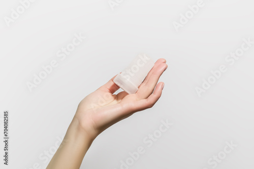 female hand holding mineral potassium alum crystal stick. natural deodorants concept