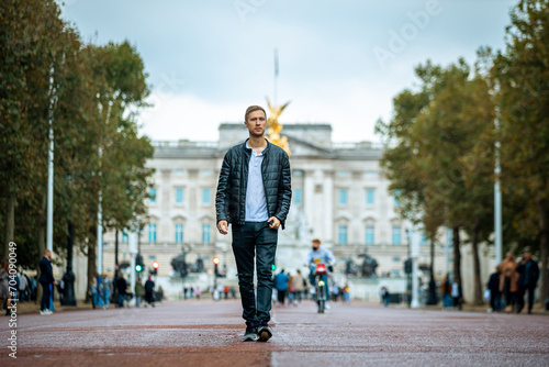 casual young man enjoying a serene moment at the majestic buckingham palace, a fusion of modern casual fashion and historical elegance in london's heart