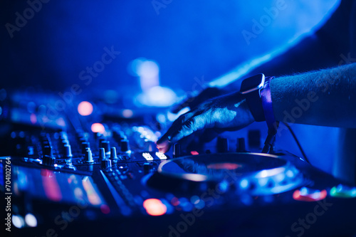 Cropped picture of dj hands performing live music on festival.