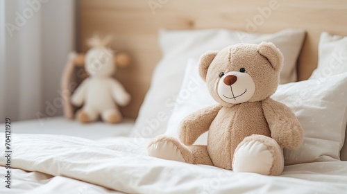 A cute teddy bear sitting on a bed