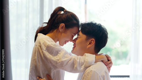 Young adult asia people fiance happy lover flirt fall in love nose lips kiss hug cuddle care trust. Sweet comfort touch newlywed asian couple life man smile look at woman face relax warm time dating.