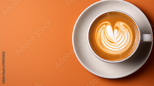 Close-up of freshly brewed latte in coffee cup on orange background