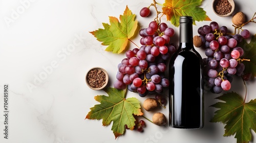 A bottle of red wine with grapes and fall leaves