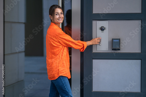 Woman using modern keypad system maintains control over access to her home.