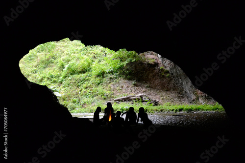 People silhouettes sitting round the fire in a cave