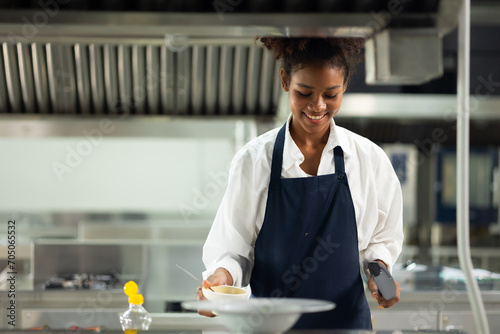 Happy African American woman standing with arms crossed while working as chef in a restaurant. Cooking class. culinary classroom. happy young african woman students cooking in cooking school.