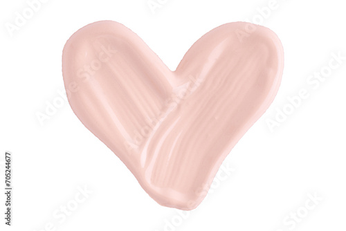 A smear of foundation cream or concealer in the shape of a heart isolated on white background, macro. Texture of cosmetic foundation or beige cream smudge, smear, stroke.