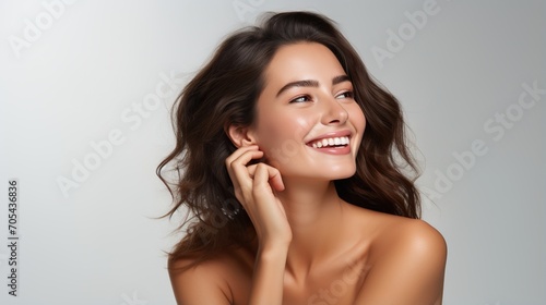 Portrait of a beautiful young woman with brown hair and white teeth smiling