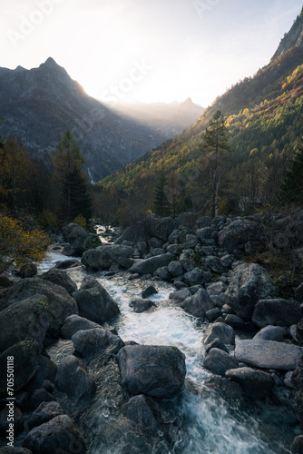 Alpine creek and rays of sunlight in Val di Mello, Italy