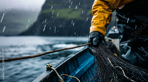 Close up of a Fisherman in rough weather handling nets on his boat. Concept of industrial fishing. Shallow field of view. 