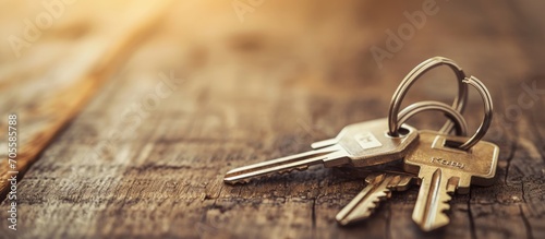 Keys with house key ring on wooden table.