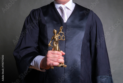 german lawyer with a robe holding a statue of Lady Justice