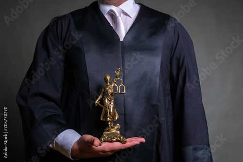 german lawyer with a robe holding a statue of Lady Justice