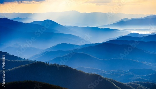 beautiful landscape of blue mountains layers during sunset with sunrays