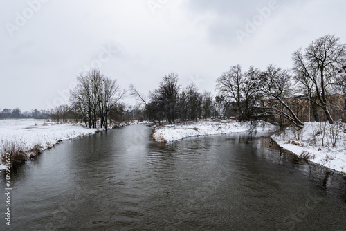 Zimowa panorama rzeki Osobłogi w popołudniowych godzinach pochmurnego szarego dnia w Zachodniej Polsce