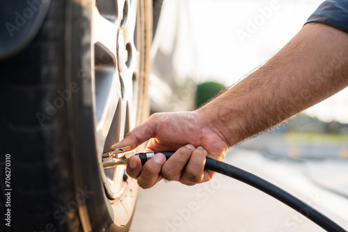Man driver hand inflating tires. Fill Air station service for vehicle tires. Checking air pressure car wheels maintenance and safety