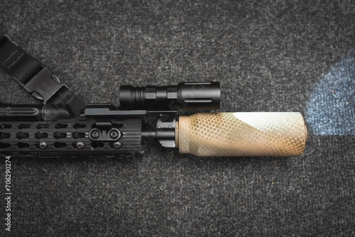 Tactical weapon, rifle with silencer and flashlight, close-up photo.