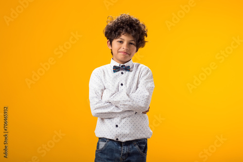 Smiling happy boy 6-7 years old. On yellow background studio