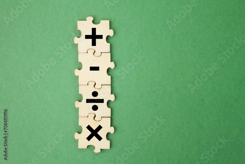 wooden puzzle with plus, minus, division and multiplication signs. mathematics learning concept