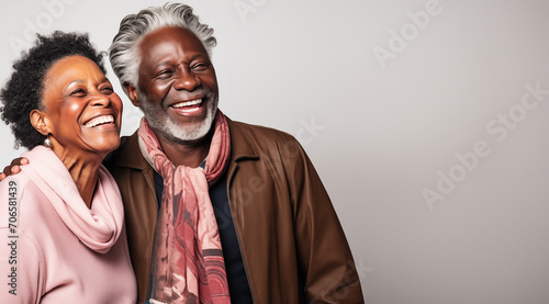 Un couple senior noir, heureux, riant et partageant un moment de bonheur intense, arrière-plan gris, image avec espace pour texte
