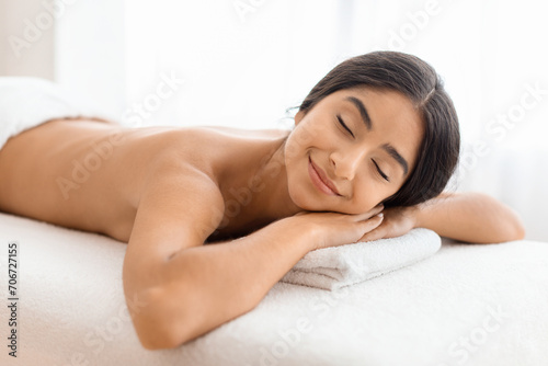 Relaxed young indian woman resting after healing back massage