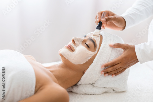 Tranquil woman with facial treatment at day spa
