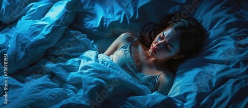 Stressed woman on bed late at night suffering from insomnia sleep apnea or stress Top view of depressed girl lying in bed late at night High angle view of awake girl in the middle of the night