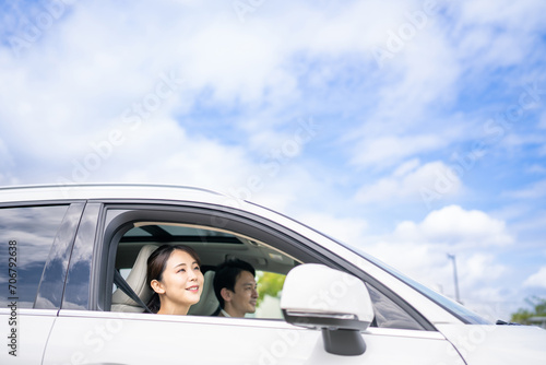 自動車を運転しながら青空を見上げる女性ドライバー