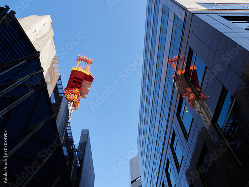 東京都の高いオフィスビルと建築現場のクレーンの様子