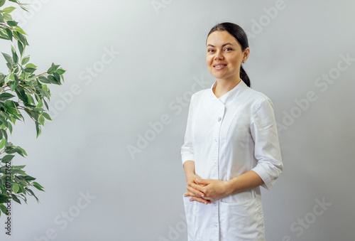 Smiling medical woman doctor overlight grey background
