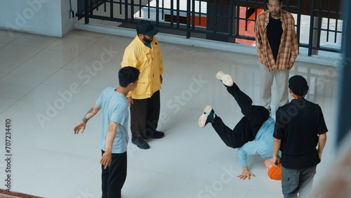 Top view of skilled hipster perform break dance surrounded by street dancer. Group of multicultural street dancer looking at professional choreographer doing freeze pose. Outdoor sport 2024. Endeavor.