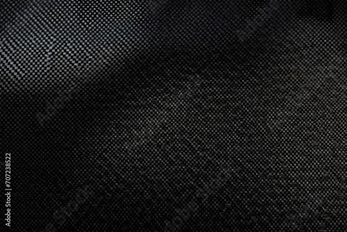 A detailed texture of carbon fiber weave, highlighting the strength and lightweight characteristics, ideal for automotive or aerospace tech themes.