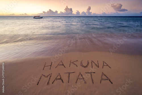 Handwritten Hakuna Matata ( no trouble) on sandy beach at sunset,relax and summer concept, Zanzibar , African beach, Tanzania.