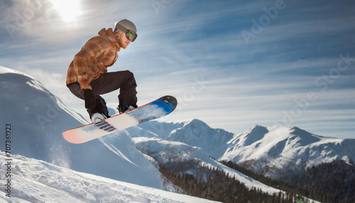 snowboarder jumping from the snowy mountains; ski freeride in sunny weather.