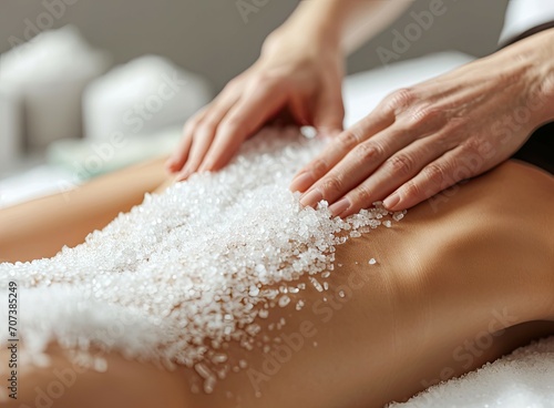 Closeup of woman receiving sea salt body scrub at spa