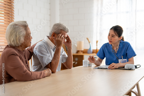 Asian caregiver nurse examine senior male patient and his wife at home.
