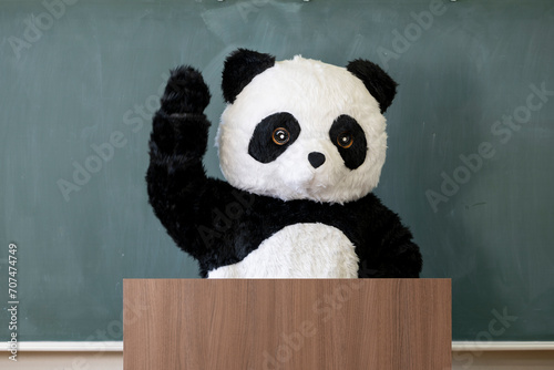 学校の教室の黒板の前に立つ可愛いパンダ