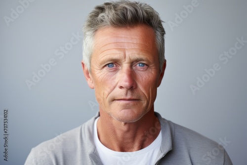 Portrait of mature man with grey hair. Isolated on grey background.