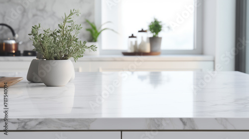 Close up of a marble table top in a white modern kitchen with built in cabinets and a counter. 