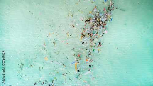Aerial view of ocean pollution with scattered plastic and debris, highlighting environmental concerns related to water contamination and marine ecosystems at risk