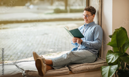 Focused calm smart european young man student in glasses read book, enjoy peace