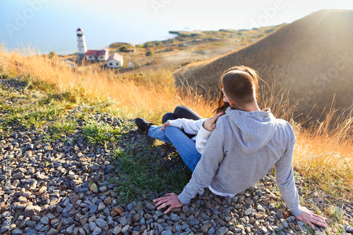 Romantic couple dressed in cozy sweaters together near the lighthouse