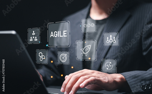 Agile development methodology, businessman use laptop with virtual screen of agile icons for process that will help you work faster By reducing step-by-step work and focusing on team communication.