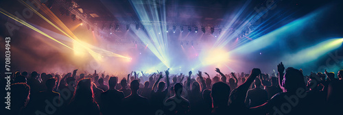 Energetic live music concert with a crowd of fans cheering and dancing under the glow of stage lights.