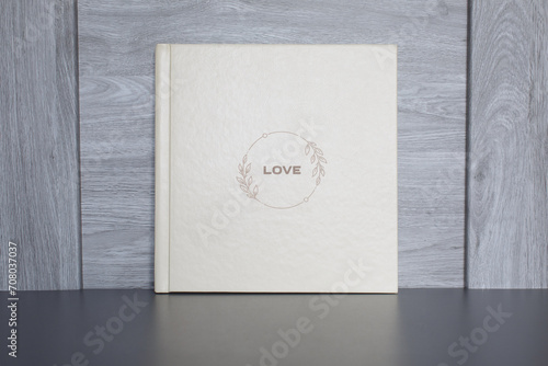 wedding or family photoalbum isolated on gray. Stylishphoto book. beige photo album with cover with a word love on gray background with copy space for text. pastel photo book close up portrait. 